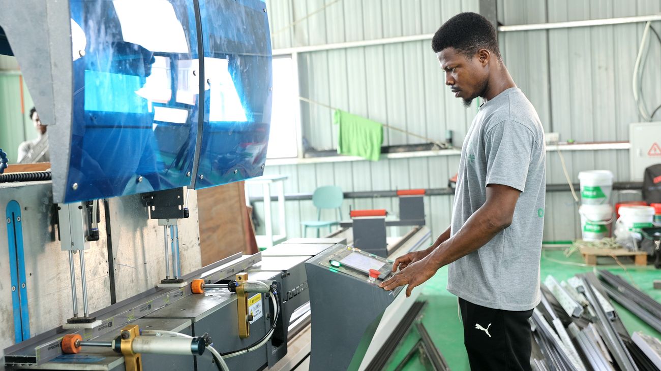 Worker handling a glass panel with a vacuum lifter